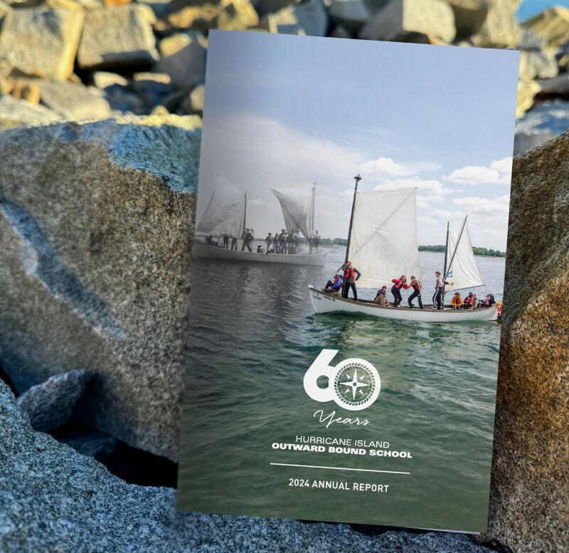 This image shows the cover of the 2024 Annual Report for the Hurricane Island Outward Bound School. The cover features a split image: the top half depicts a historical black and white photo of sailboats, while the bottom half shows a modern color photograph of a sailboat with people on board, sailing on the water. A prominent "60 Years" logo is also visible.